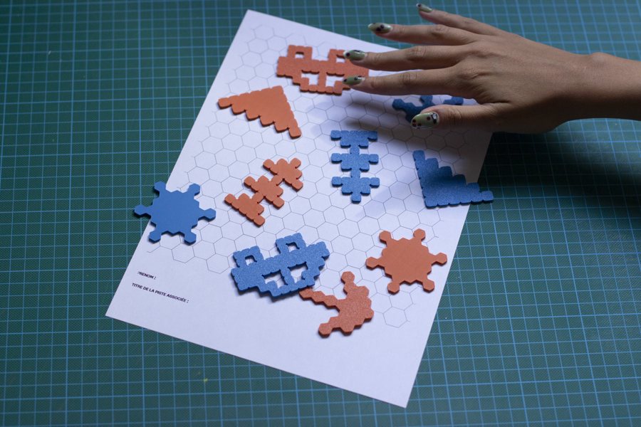 Formes graphiques colorées posées sur une feuille, sur un tapis de découpe